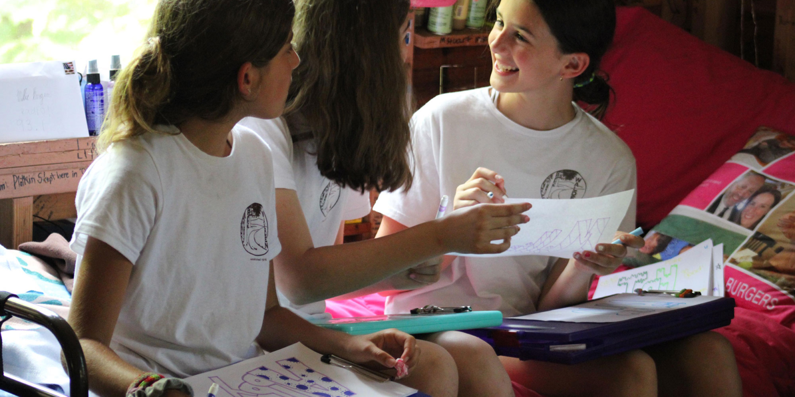 three girls writing letters home from camp