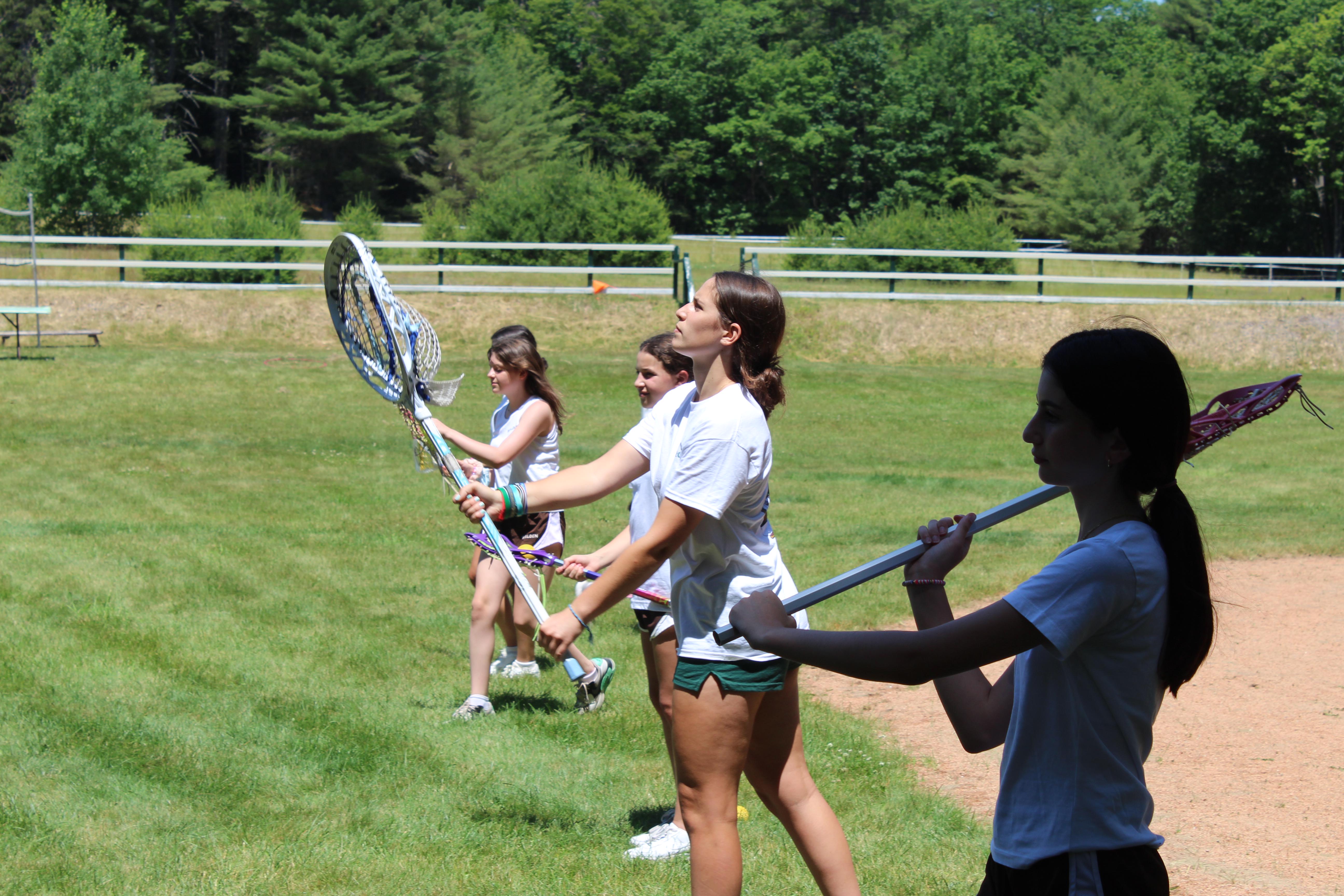 Girls practicing lacrosse drills