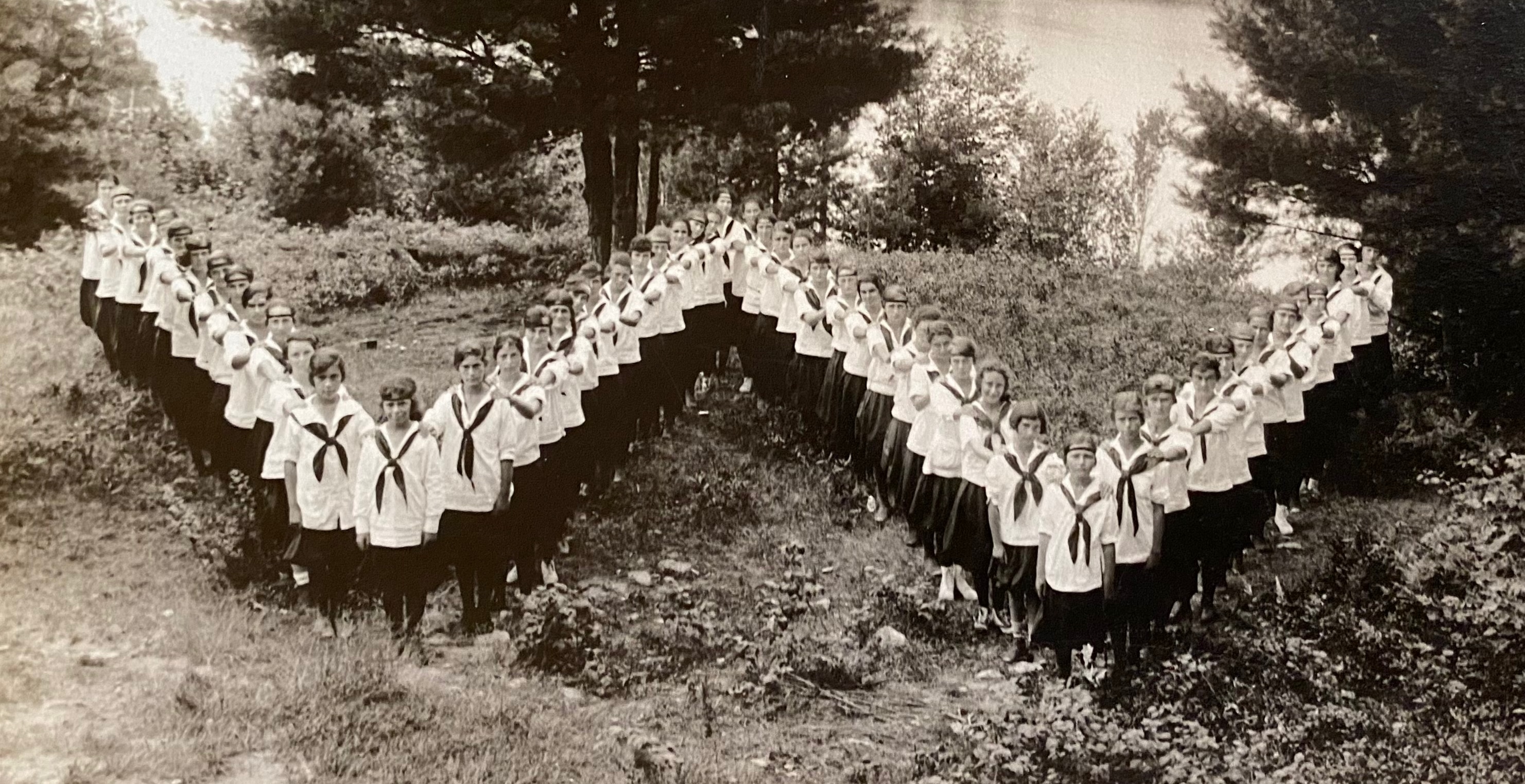 Vintage photo of campers lining up in shape of letter W.