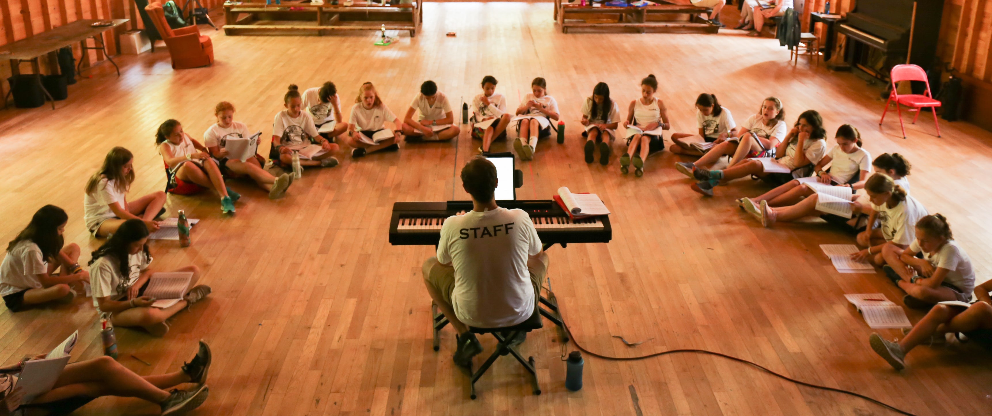 A Camp Walden counselor leads campers in song
