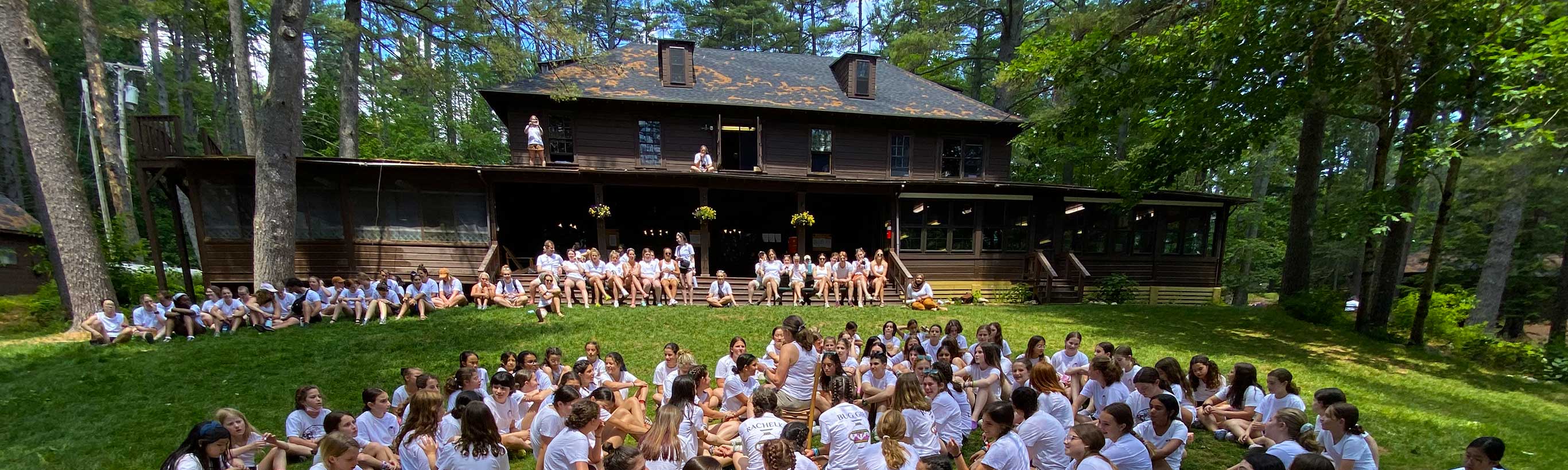 The Camp Walden lodge with a crowd of girls in front.
